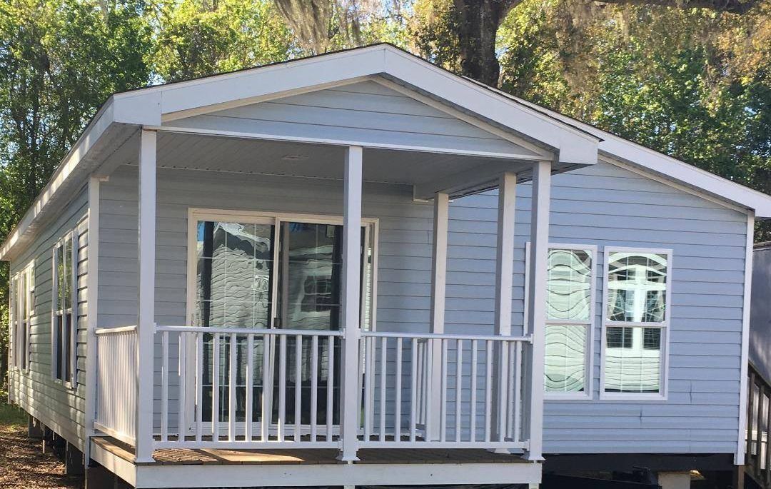 Light blue modular home with a porch and white trim.