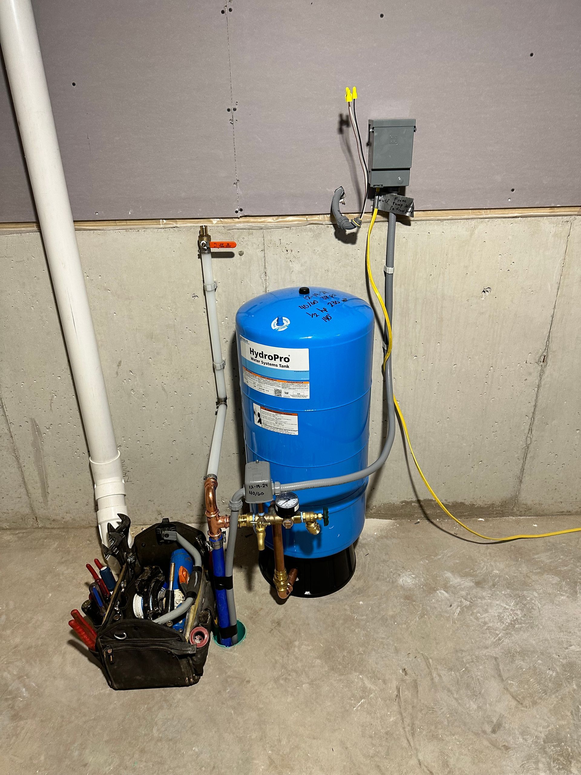 Blue air compressor with attached hoses and tools in a workshop corner
