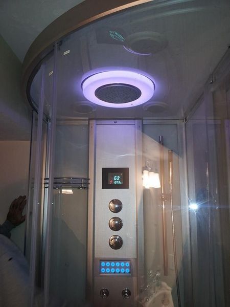 Shower stall with digital control panel, illuminated with purple light.