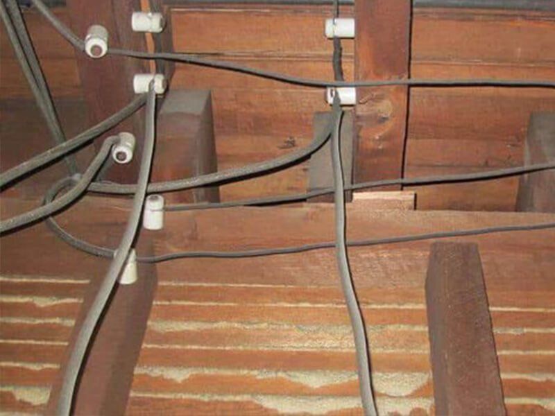 Two people installing something near a TV and bookshelf. They are wearing shirts with the logo of 