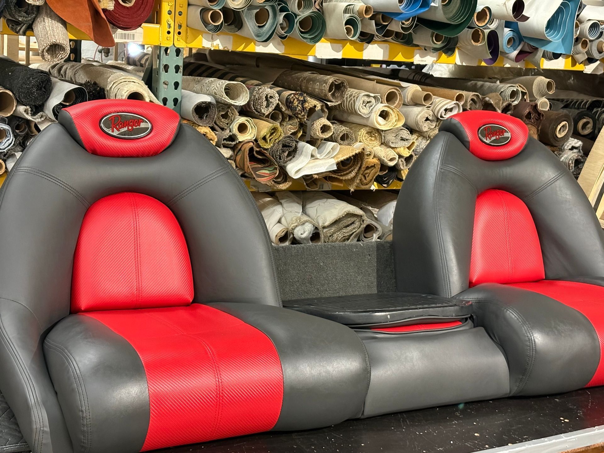 Damaged red and gray boat seats with a mobile detailing truck in the background - After
