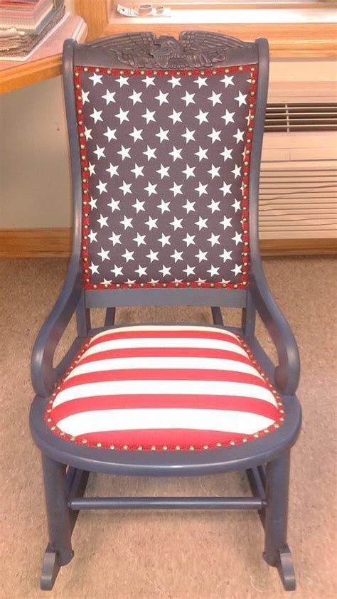 Child's rocking chair with navy blue frame and upholstered back (white stars on navy) and seat (red and white stripes).