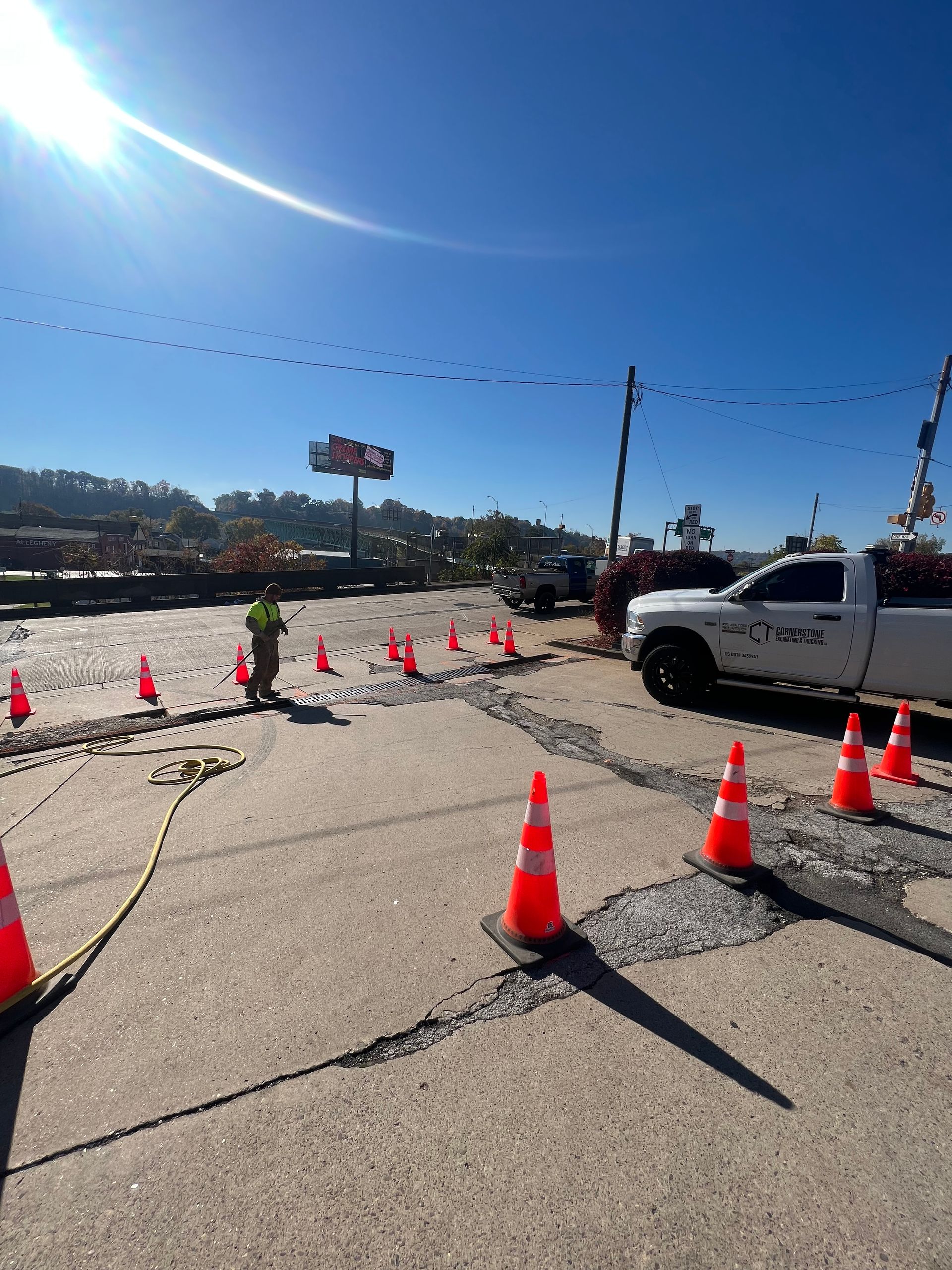A white truck is parked in a parking lot surrounded by orange cones.