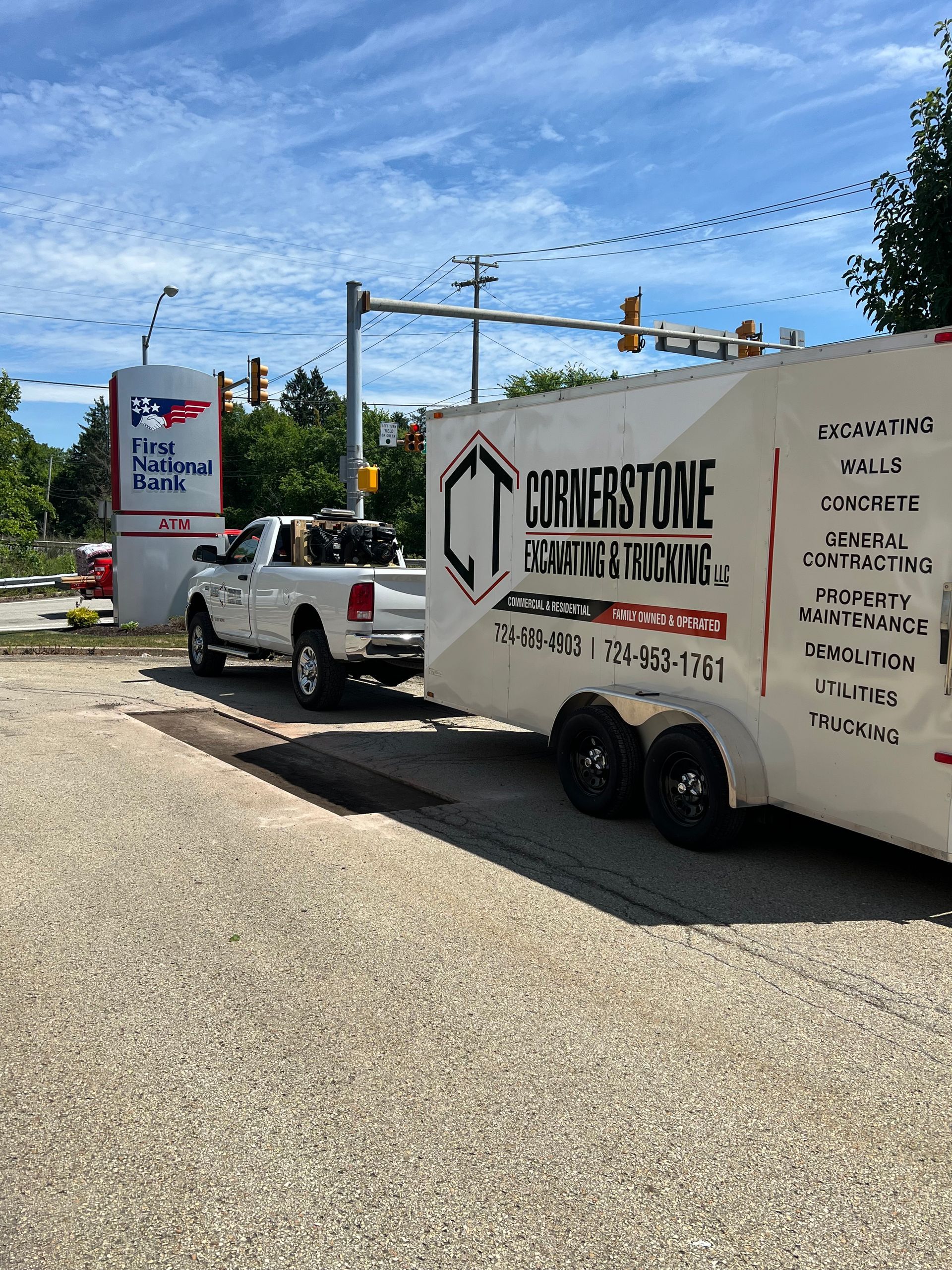 A truck and trailer are parked on the side of the road.