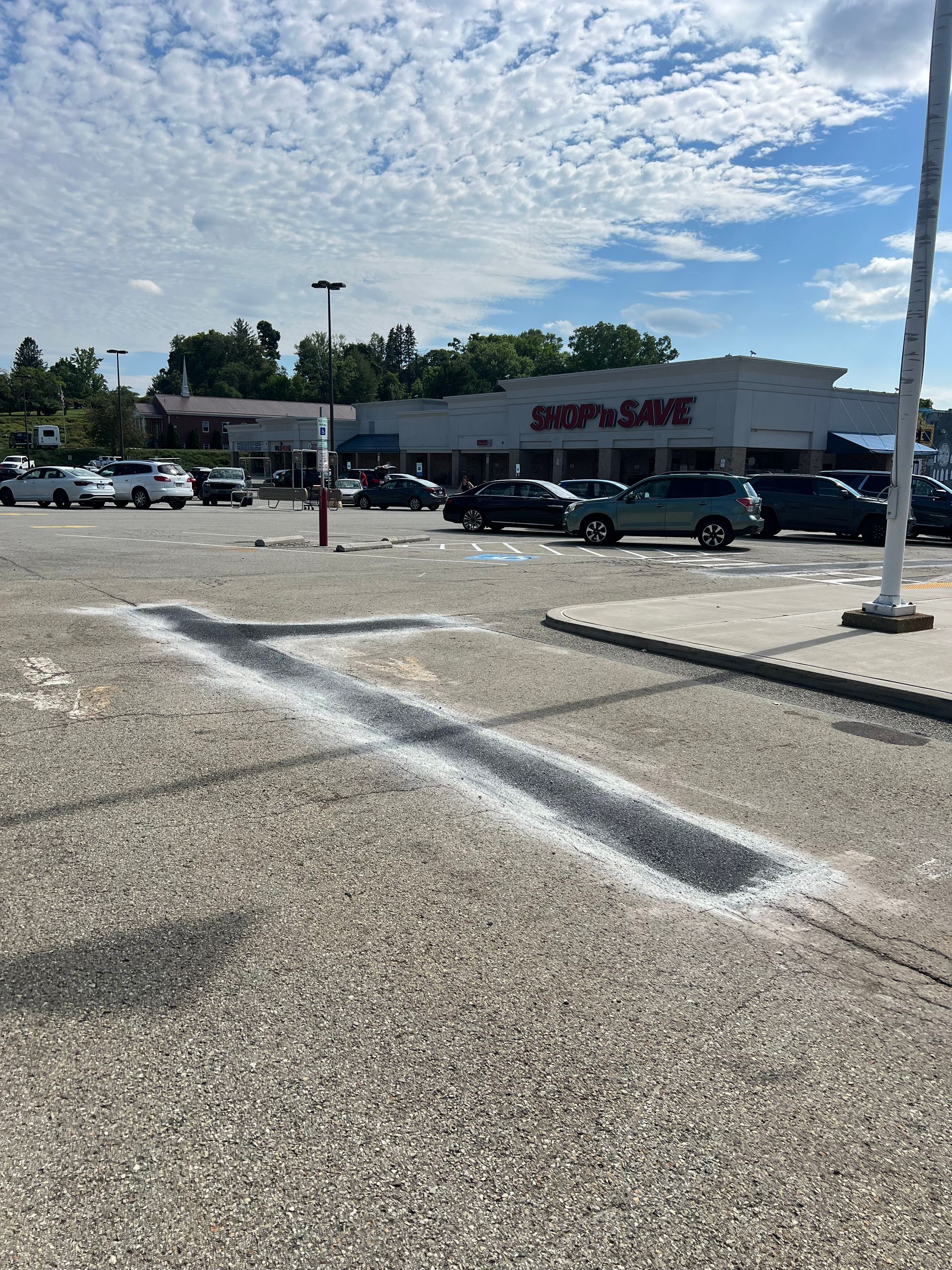 A parking lot with cars parked in front of a store called staples
