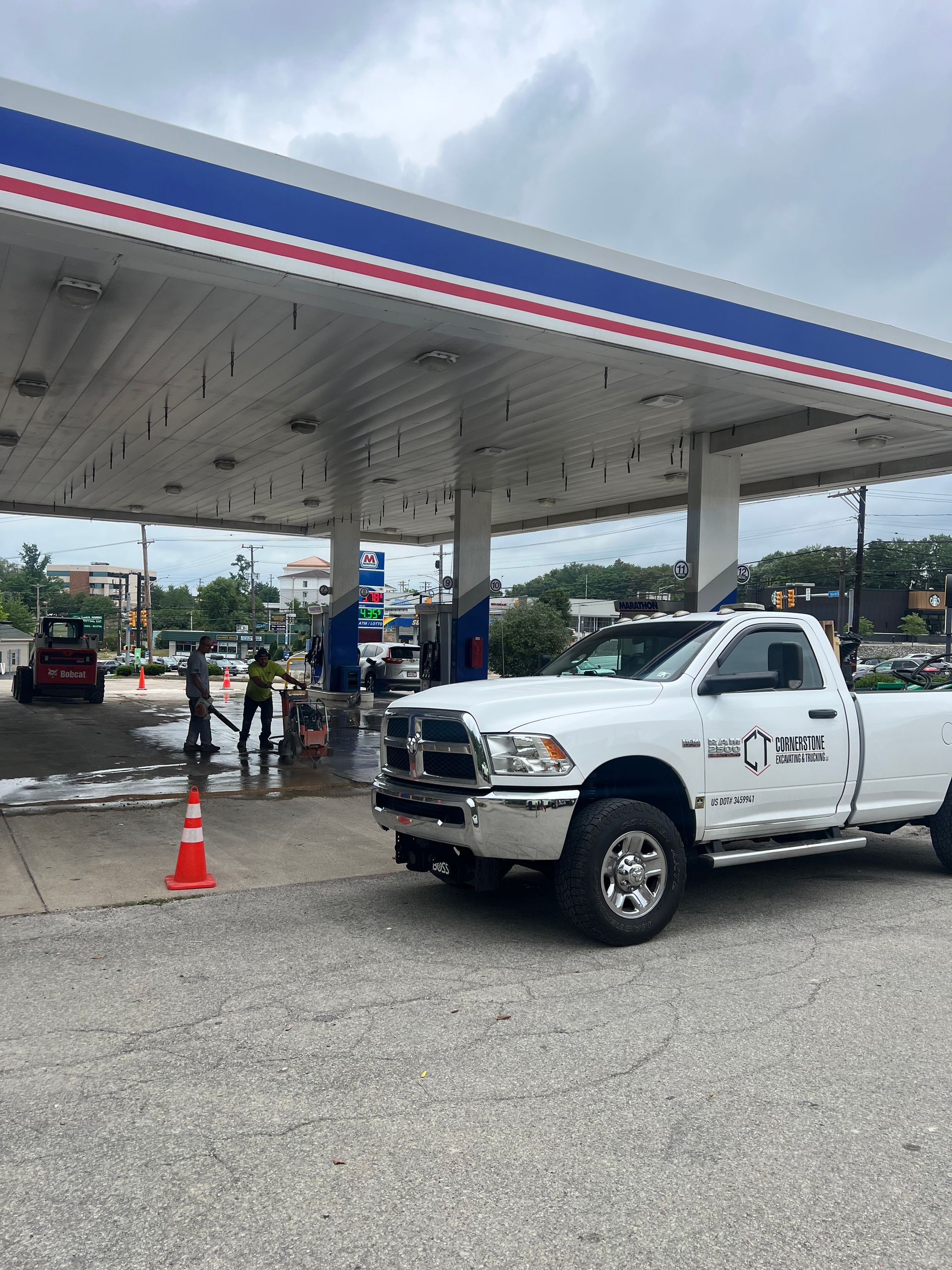 A white truck is parked in front of a gas station