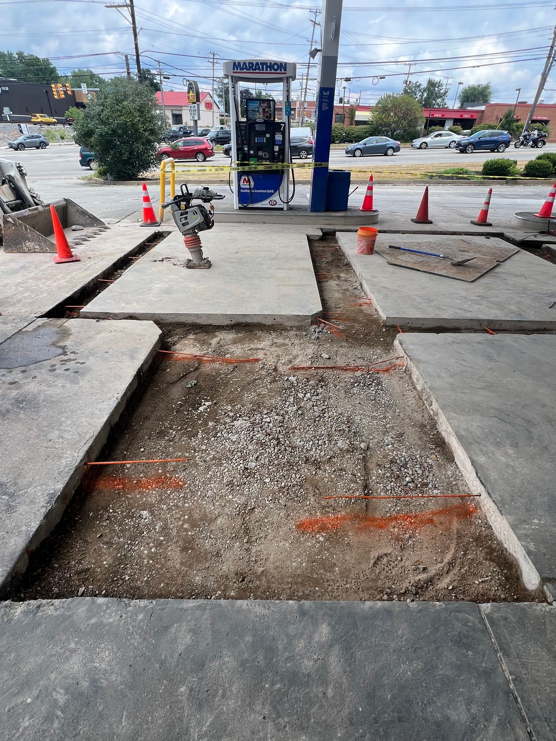 A construction site with a gas station in the background