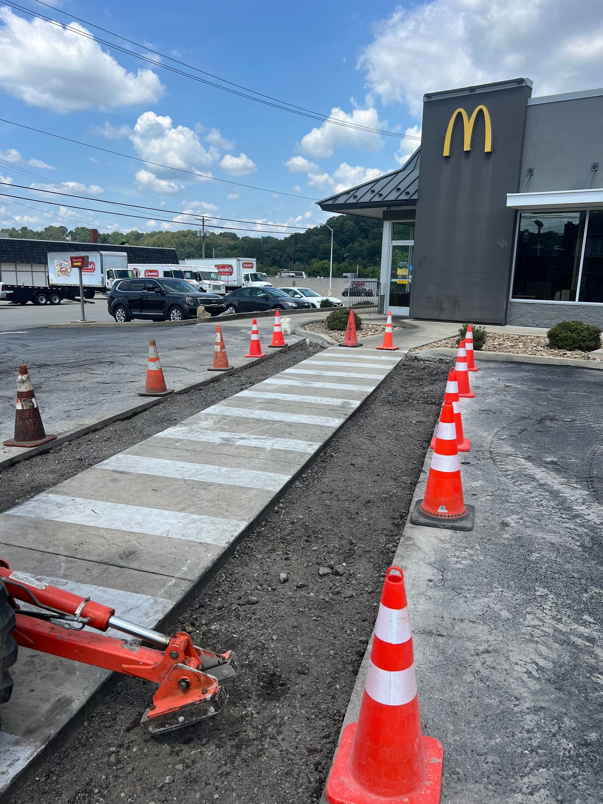 A mcdonald 's restaurant with a walkway and cones in front of it.