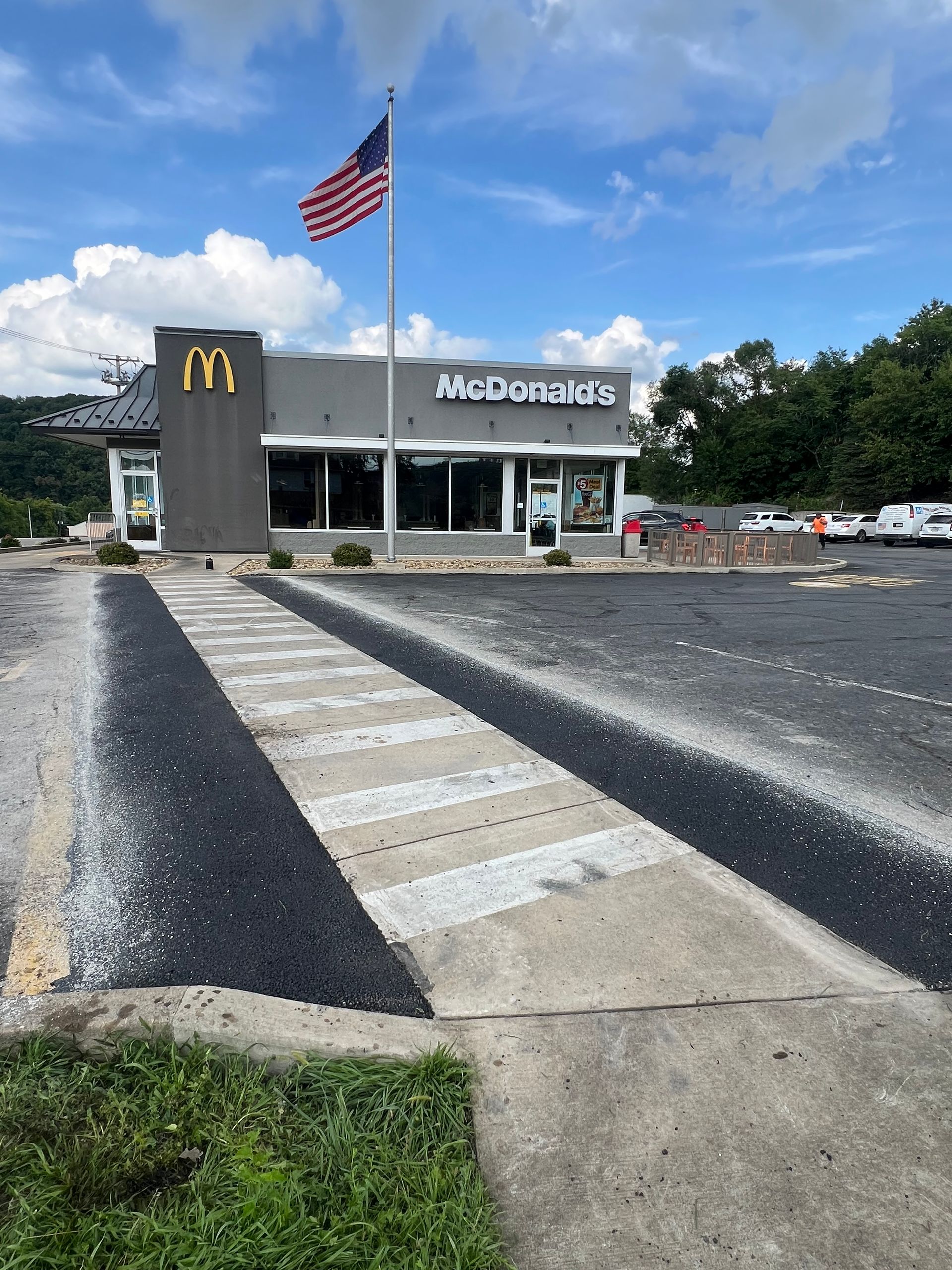 A mcdonald 's restaurant with an american flag flying in front of it