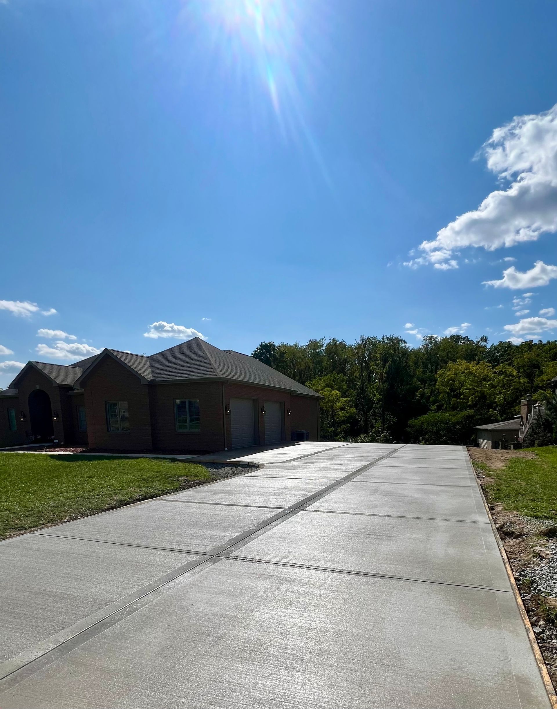 A brick house with a concrete driveway leading to it