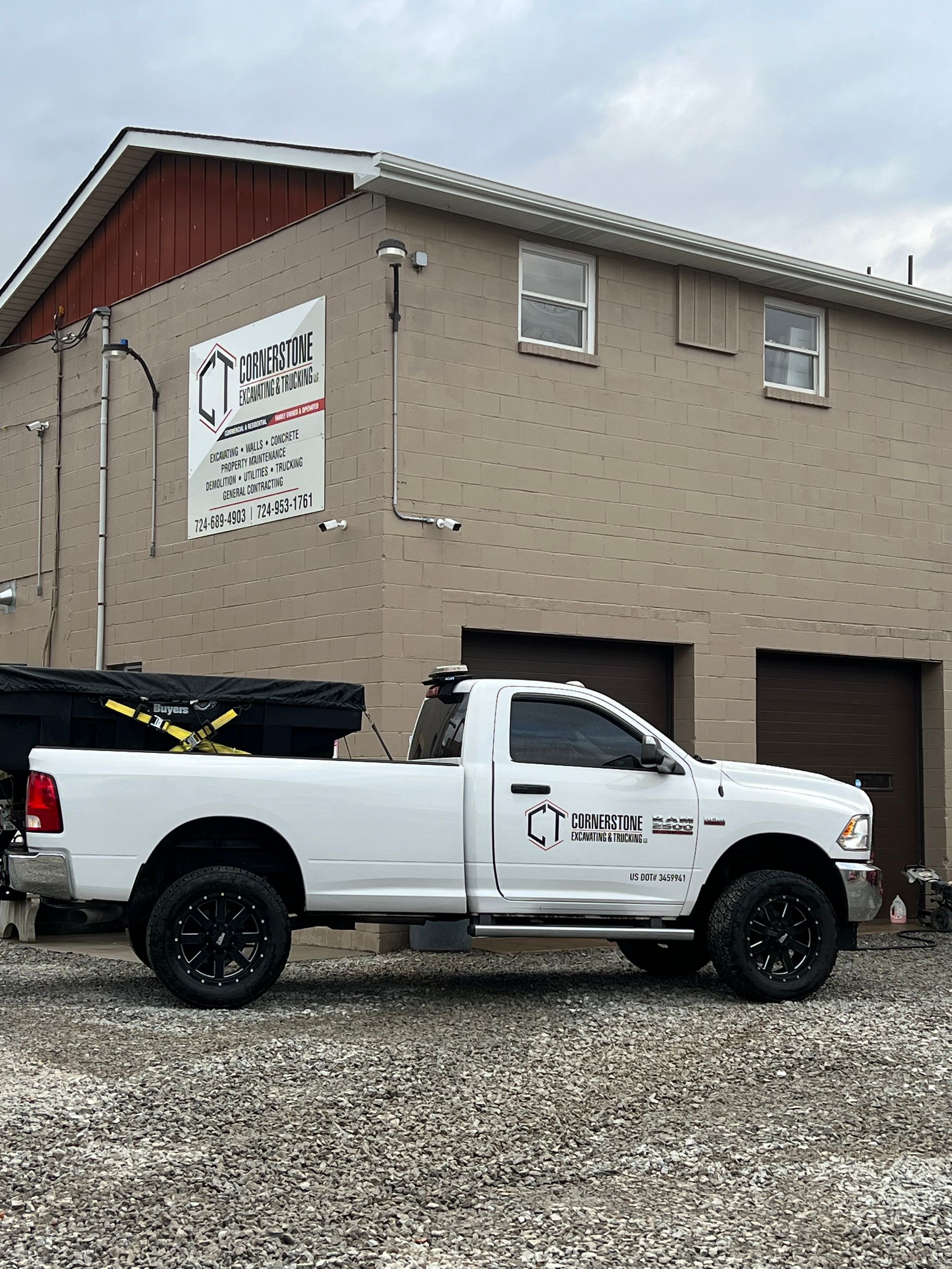 A white truck is parked in front of a building.