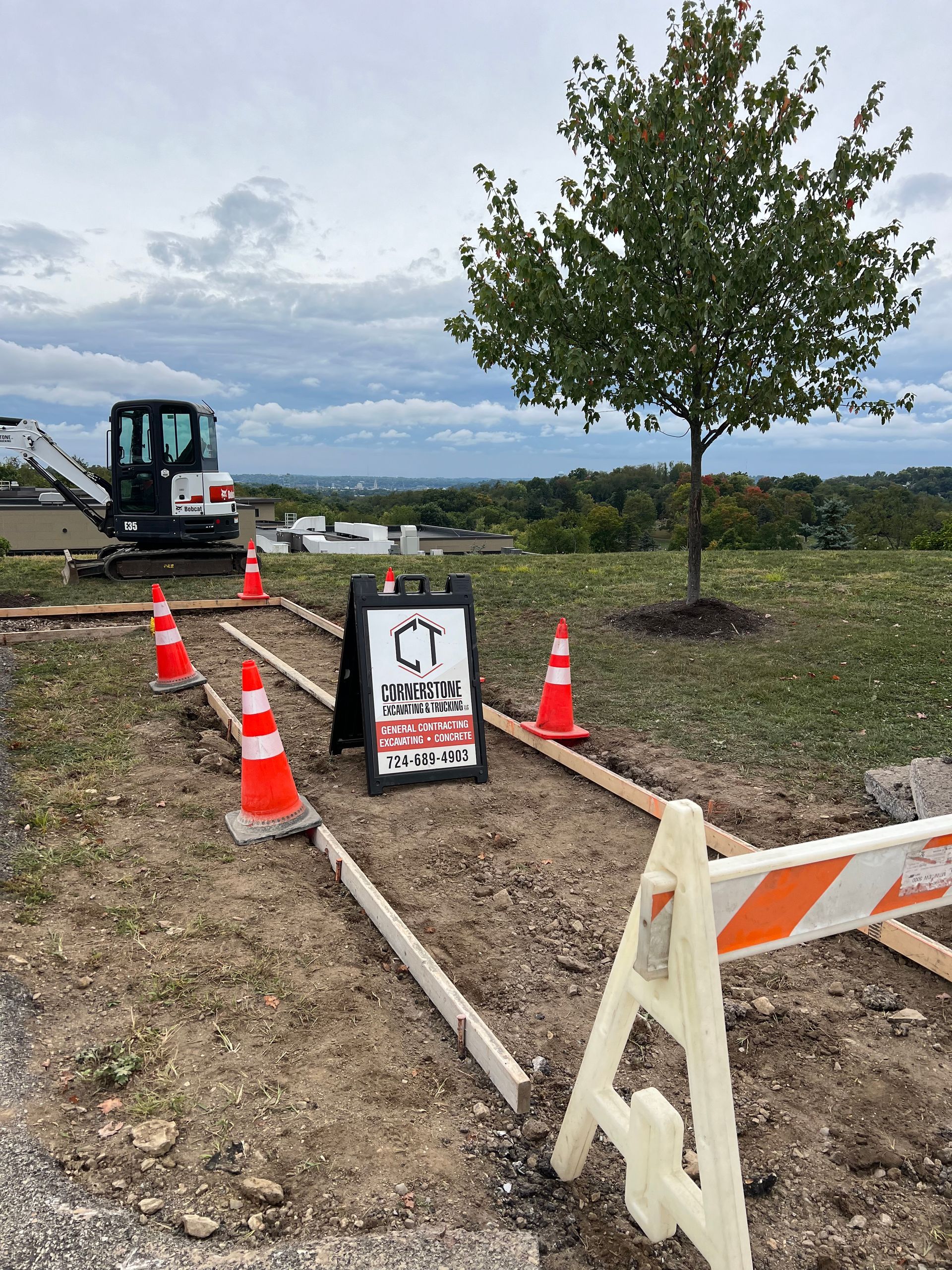 A construction site with cones and a sign on the side of the road.