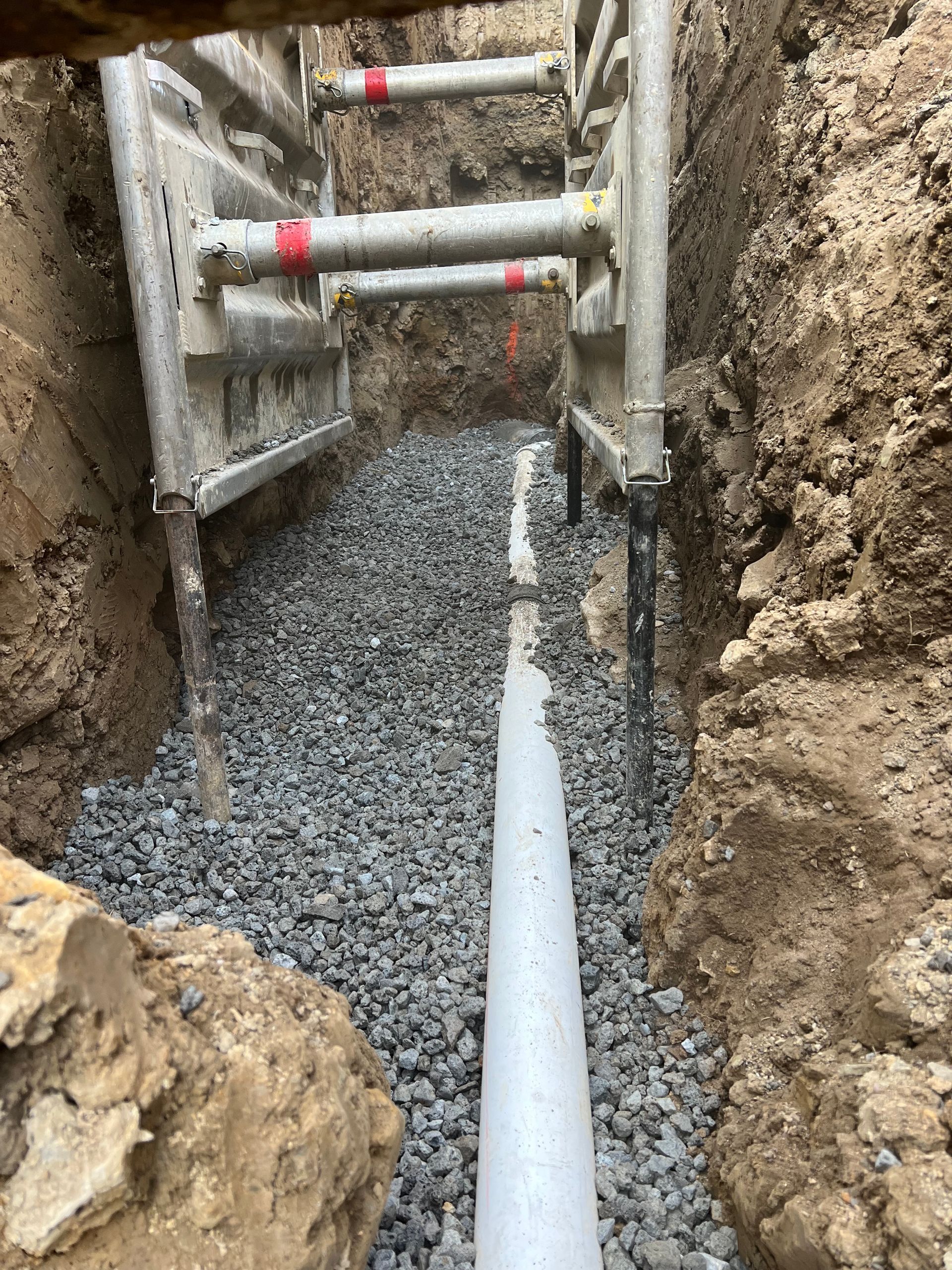 A pipe is being installed in a hole in the ground.