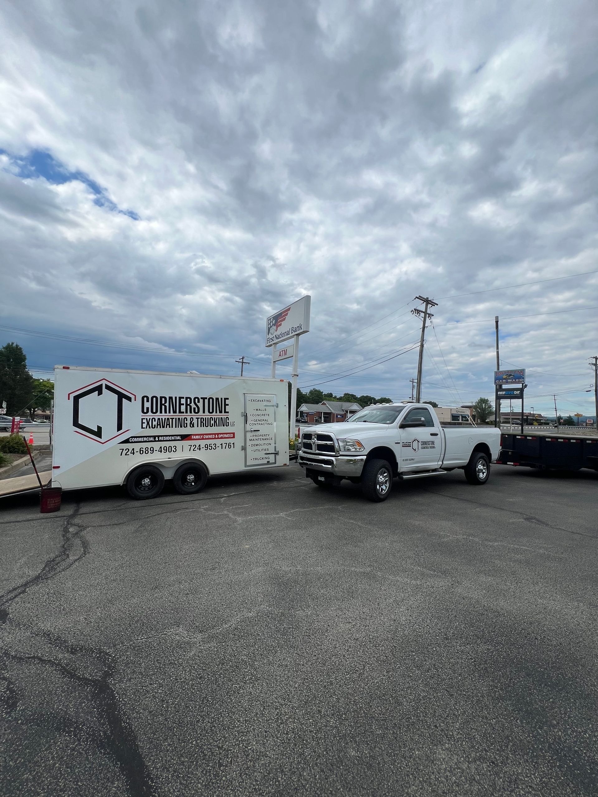 A truck is towing a trailer in a parking lot.
