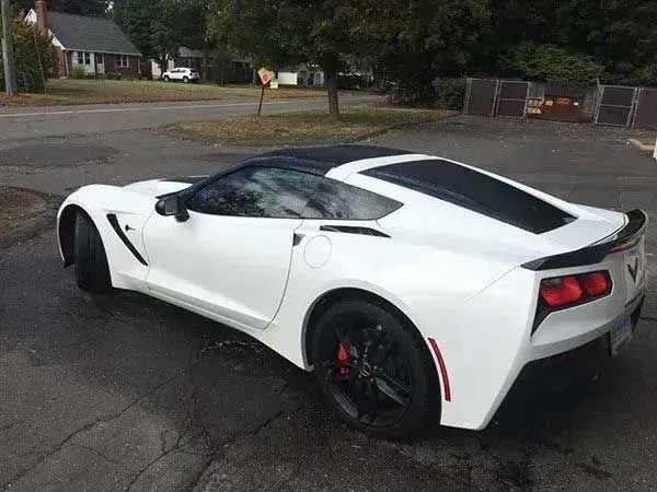 White sports car with black accents parked on asphalt.