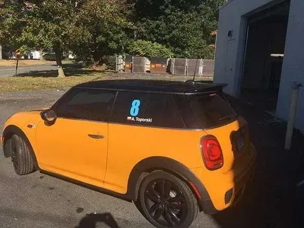 Orange Mini Cooper with black roof and wheels; 