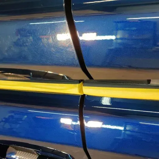 A close up of a blue car with a yellow stripe on the door.