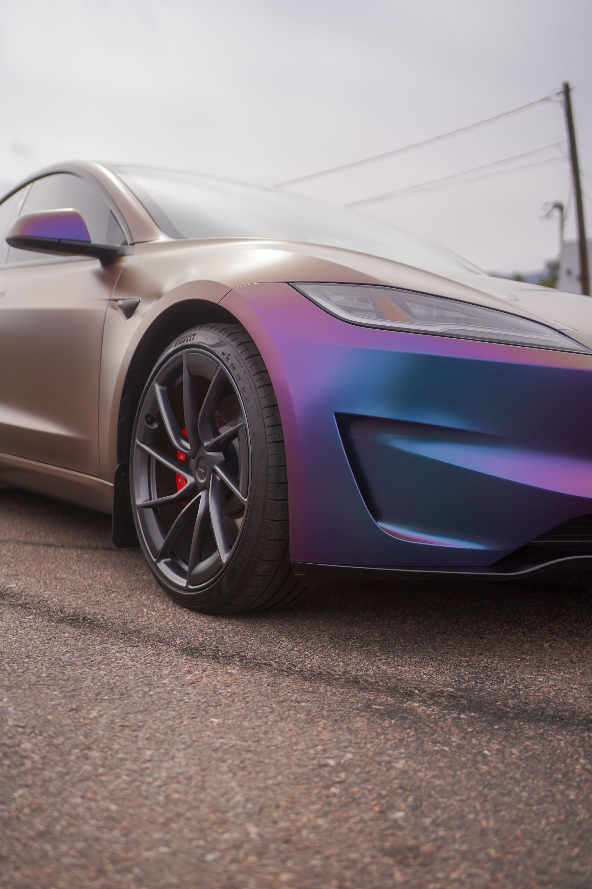 A tesla model s is parked on the side of the road.