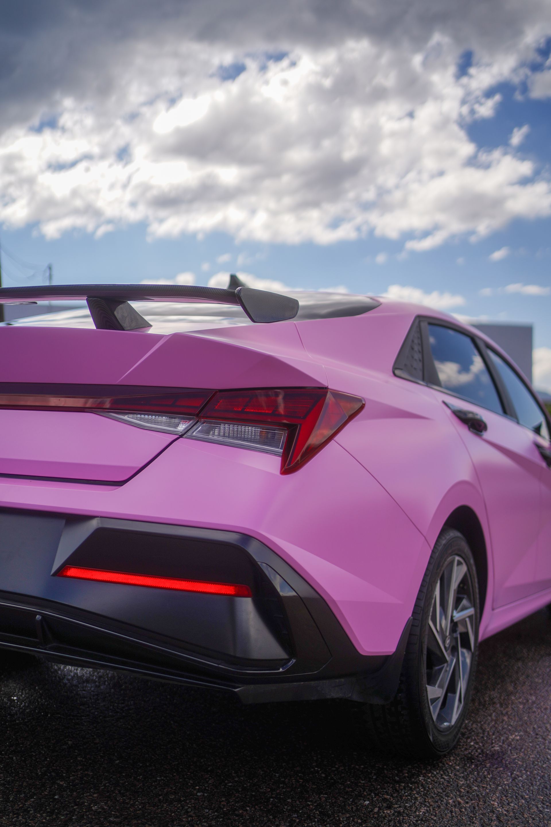 A pink sports car is parked on the side of the road