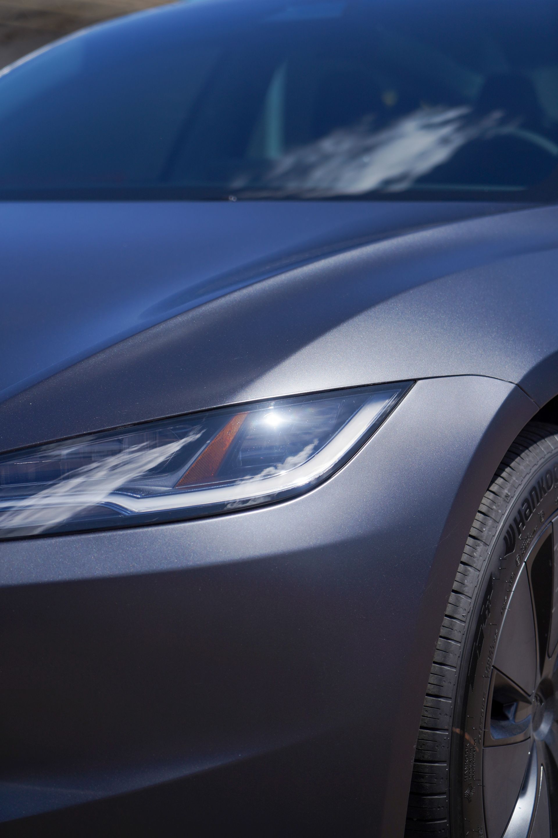 A close up of a car 's headlight on a sunny day