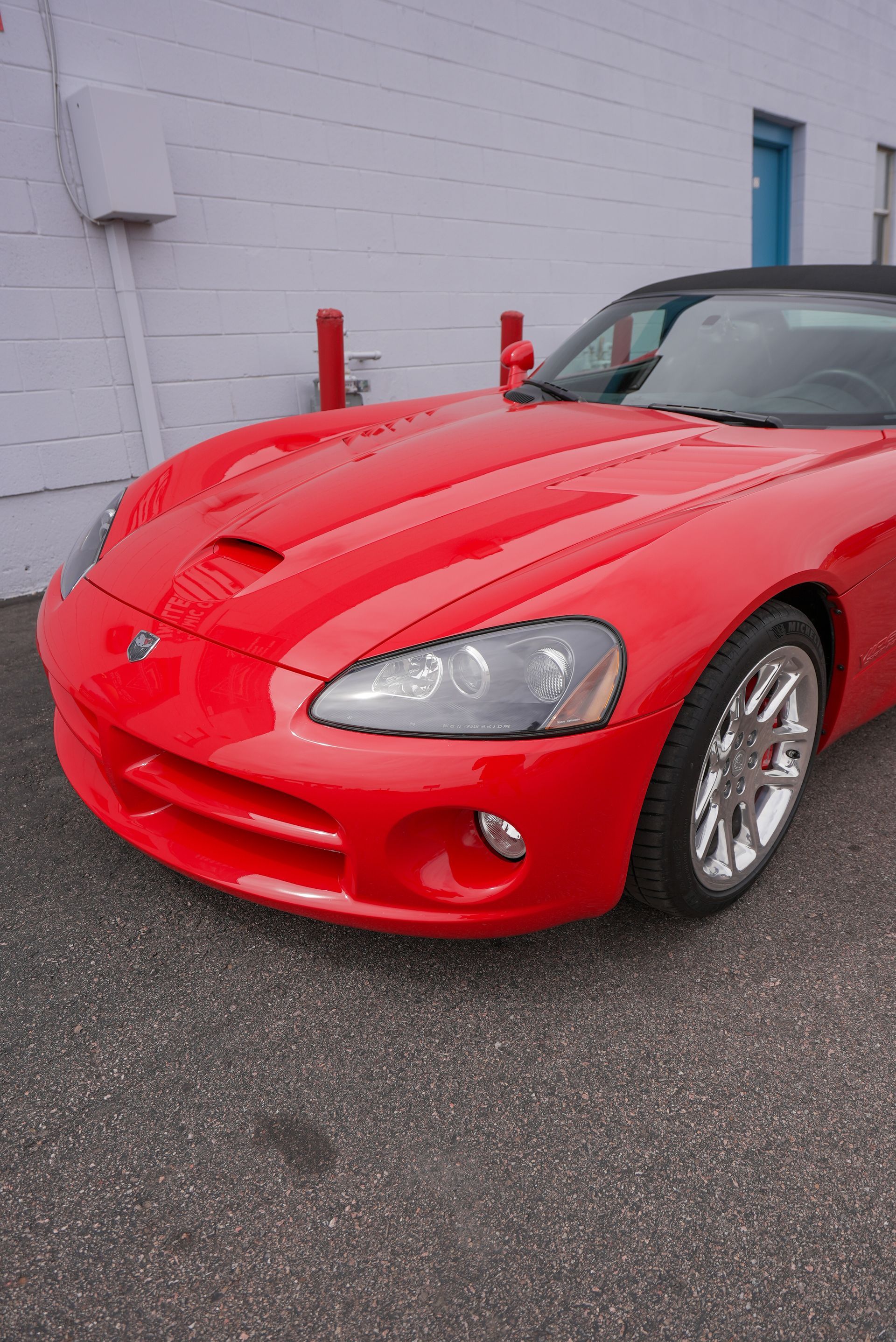 A red dodge viper is parked in front of a building.