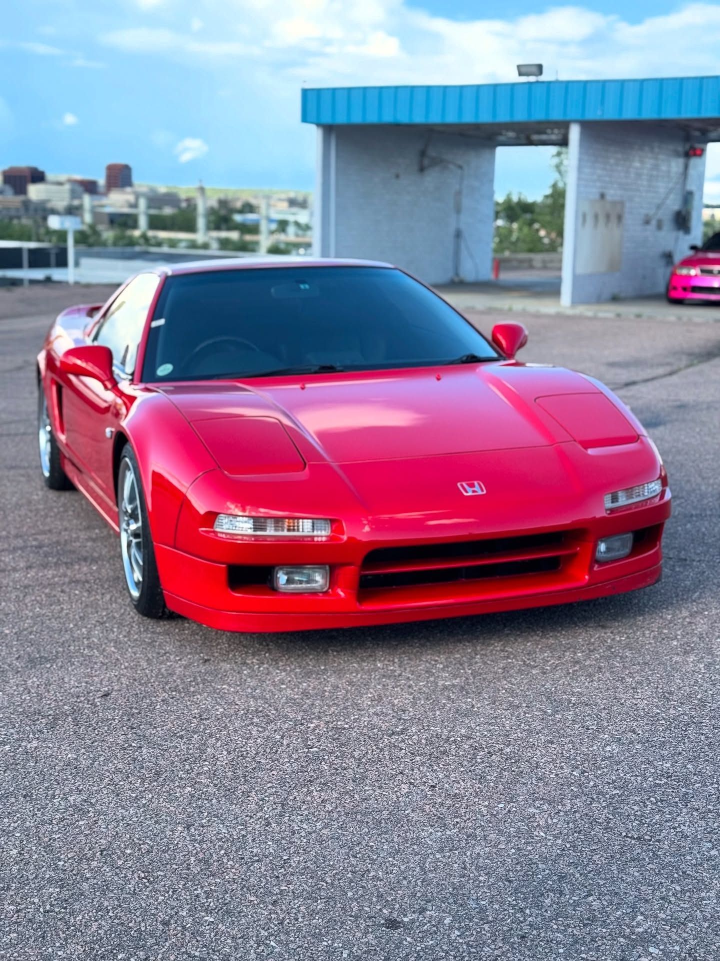 A red sports car is parked in front of a building