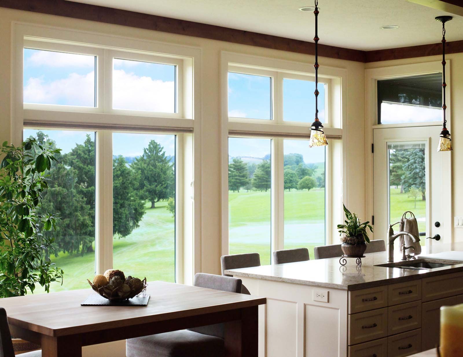 a kitchen with a table and chairs and a view of a golf course