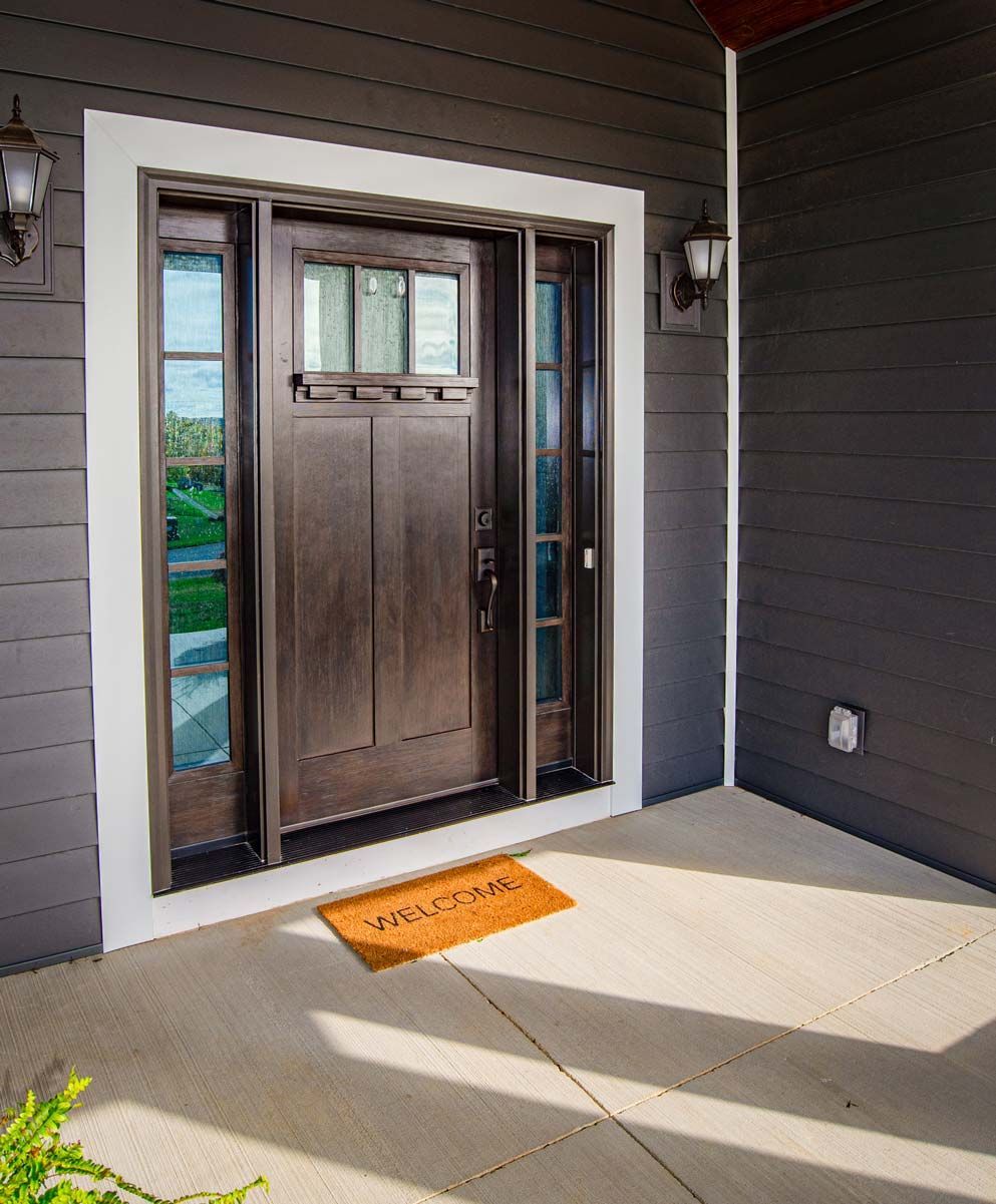 a brown door with a welcome mat in front of it