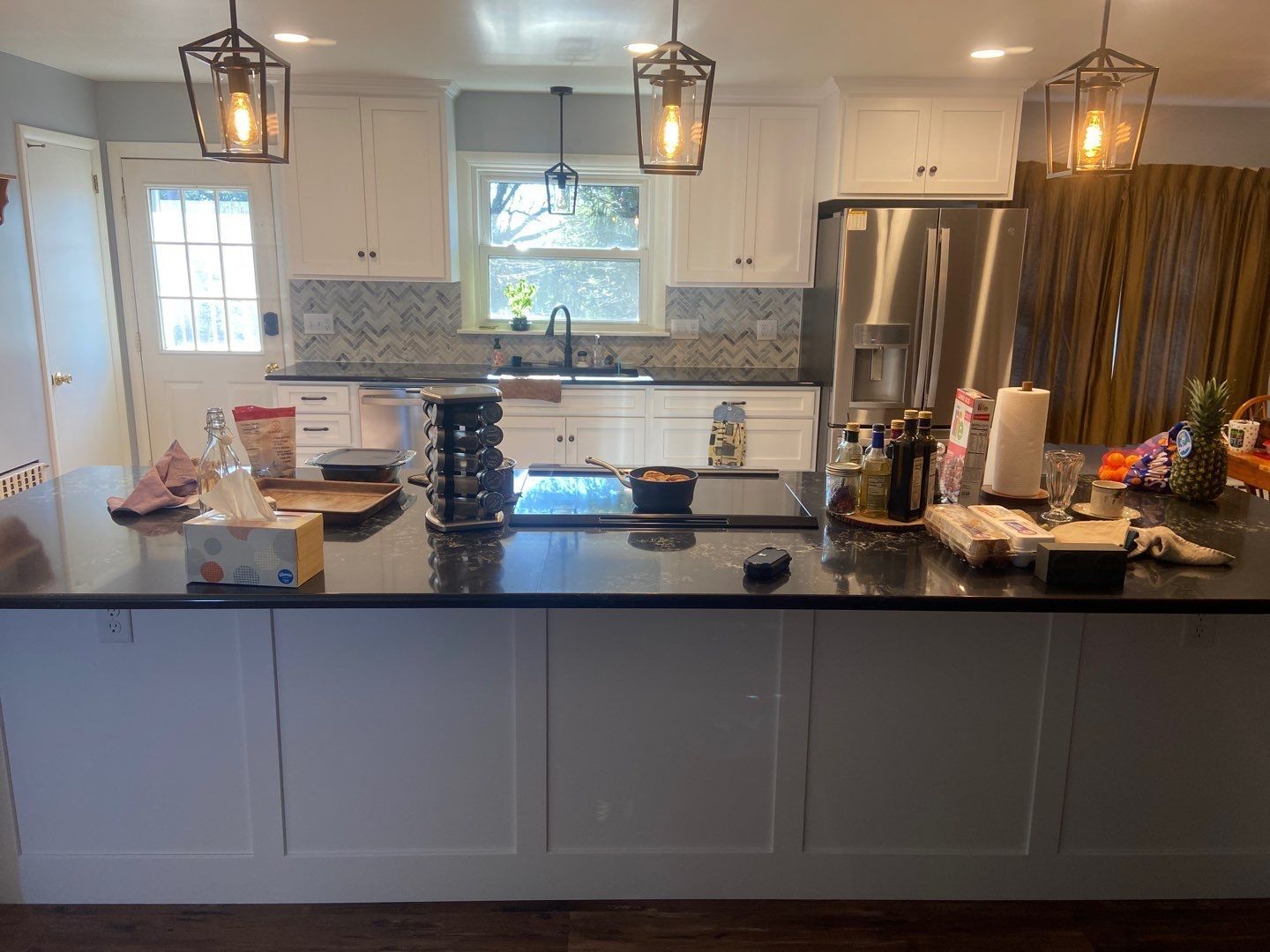 a kitchen with white cabinets, black counter tops, and stainless steel appliances