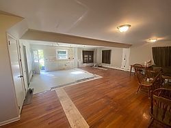 a living room with hardwood floors and a table and chairs .