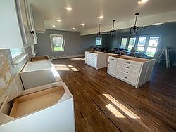 a kitchen is being remodeled in a house with hardwood floors and white cabinets .