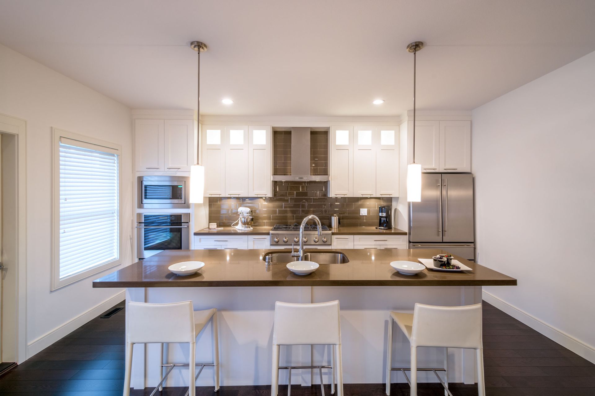 a kitchen with white cabinets and stainless steel appliances and a large island