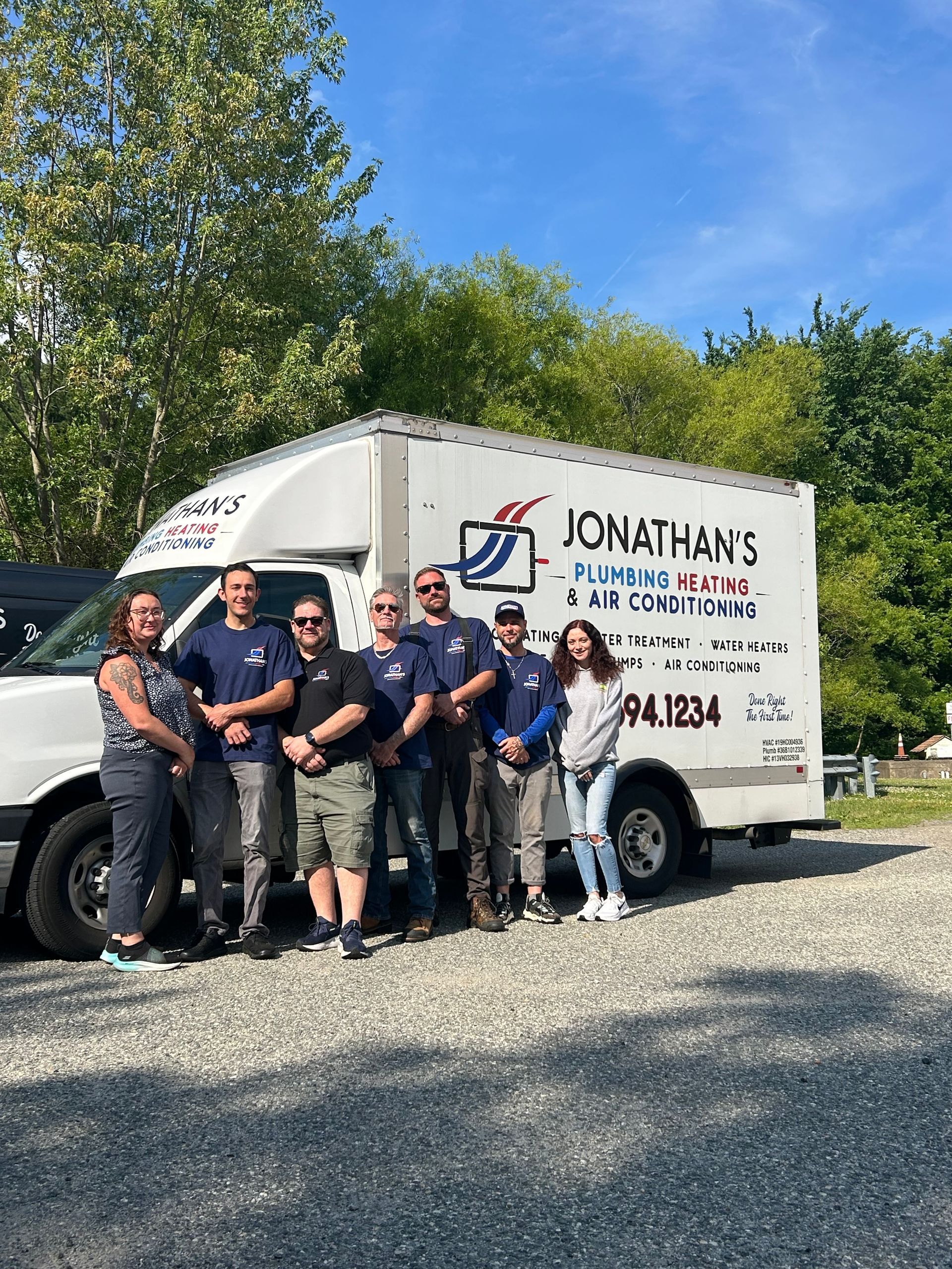 Group posing beside a Jonathan's moving truck on a sunny day