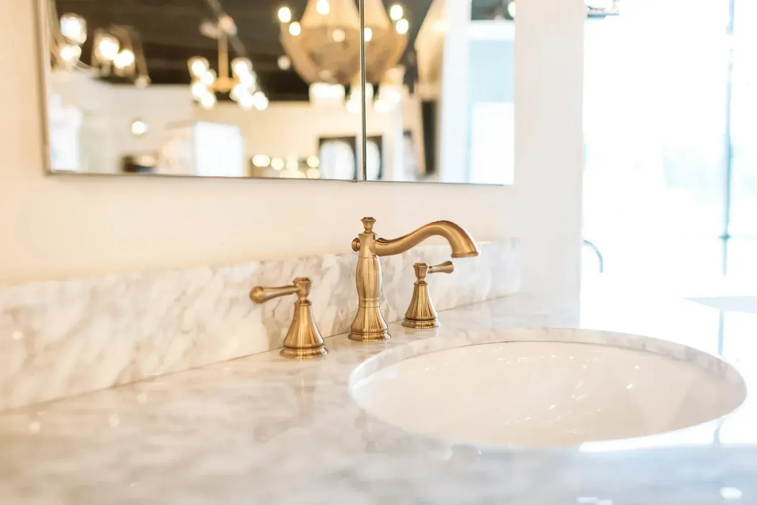 Elegant bathroom vanity with marble counter, gold faucet, and round white sink