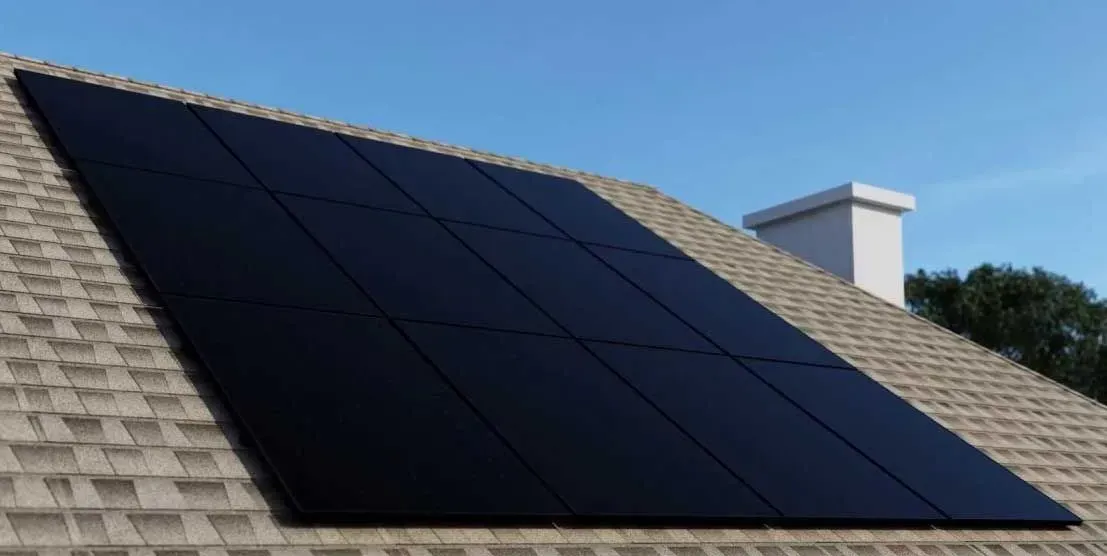 Black solar panels mounted on a shingled roof beside a white chimney