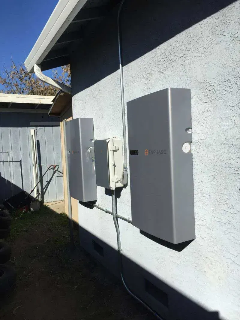 Exterior wall with gray utility boxes and electrical equipment in sunlight