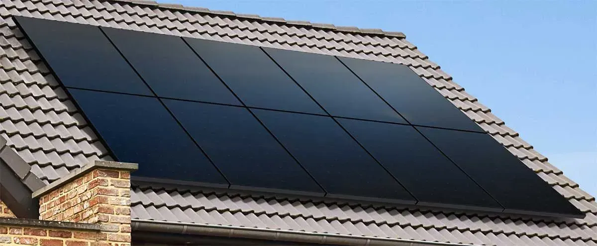Solar panels mounted on a house roof under a clear blue sky