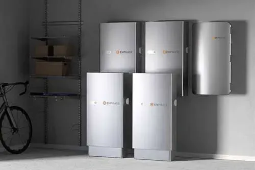Several silver metal cabinets stacked in a room beside a shelving unit and bicycle.