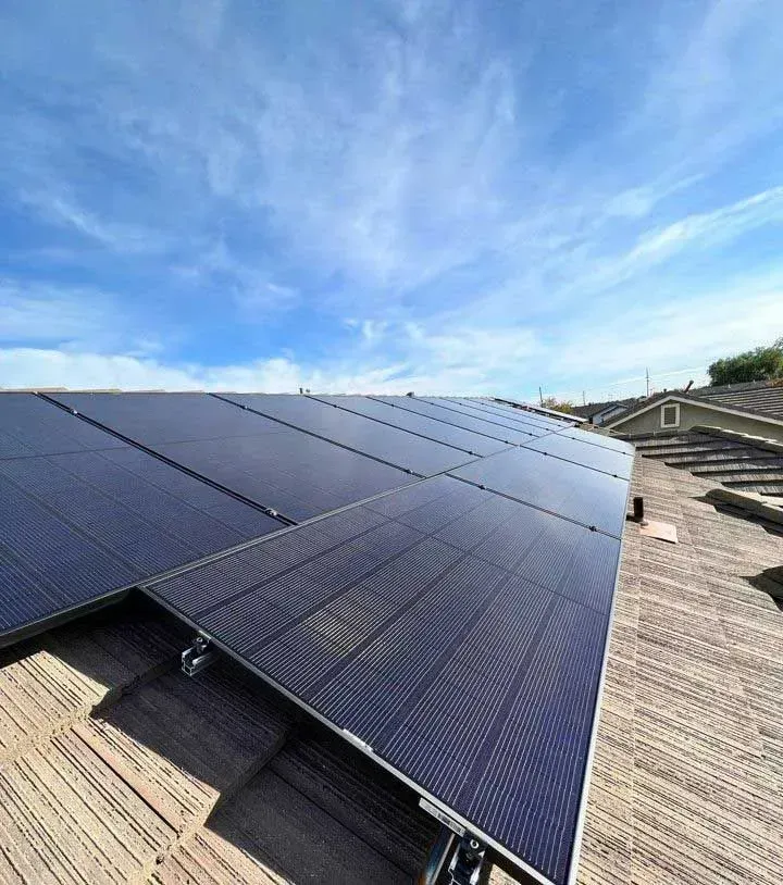 Solar panels on a rooftop under a bright blue sky