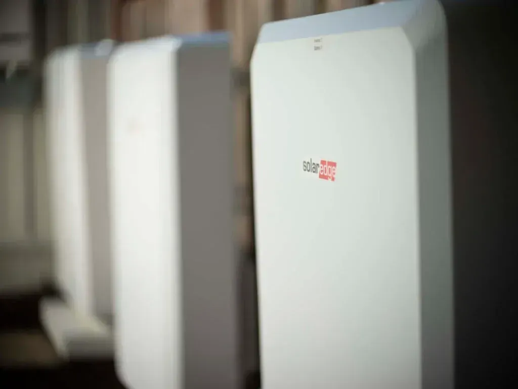 Row of white wall-mounted devices with a small red logo, viewed in a dim indoor setting