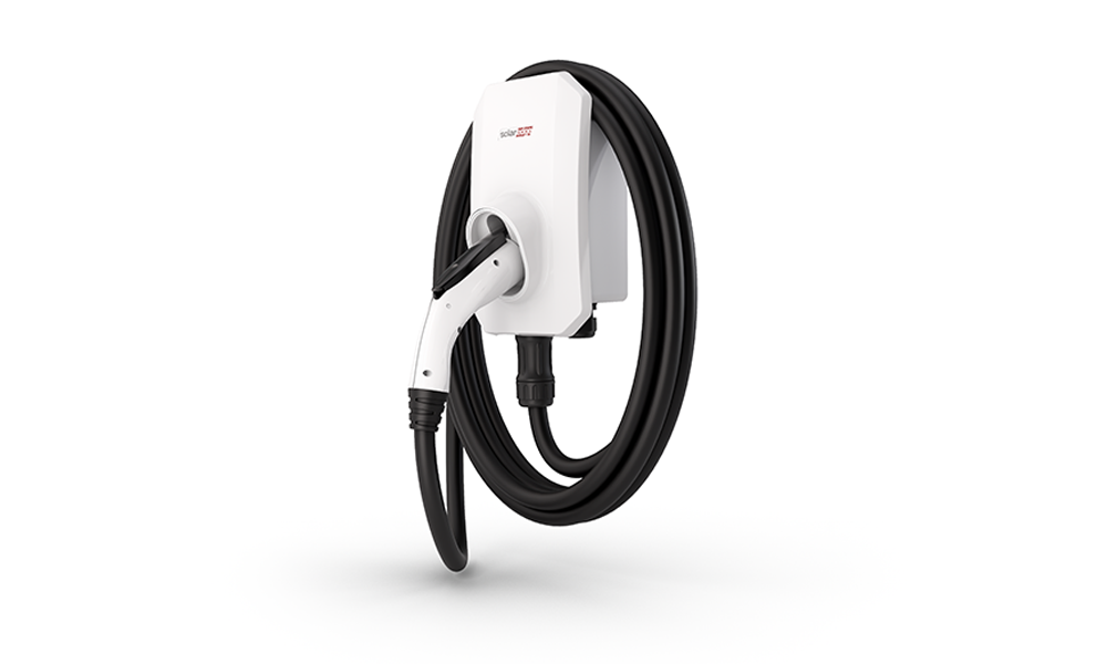 White electric vehicle charging station with coiled black cable on a plain background