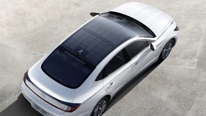 Silver sedan with panoramic sunroof viewed from above on a light concrete surface
