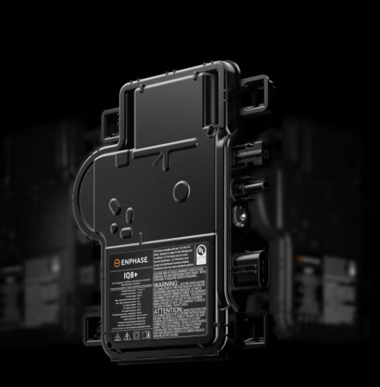 Black rugged electronic device or battery pack with cables and labels on a dark background
