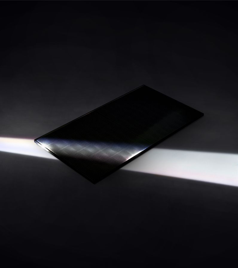 Dark rectangular object reflecting a bright white beam across a black background