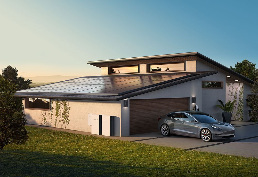 Modern house with sloped roof, car in driveway, and grassy yard at sunset