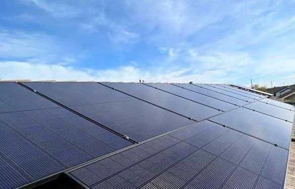 Solar panels covering a rooftop under a blue sky