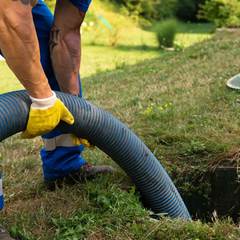 A man is pumping a hose into a hole in the ground.