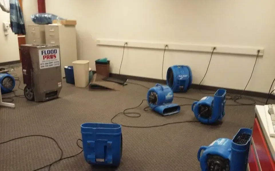 A room with a bunch of blue fans and a sign that says flooded spaces.