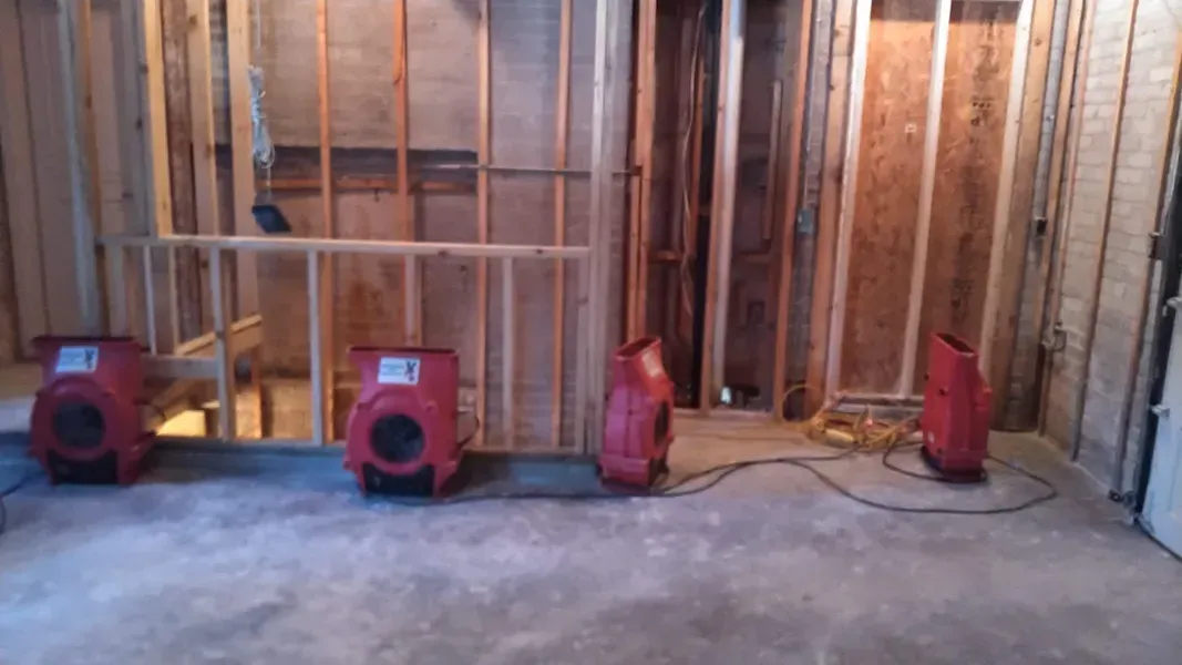Three red fans are sitting in a room under construction.