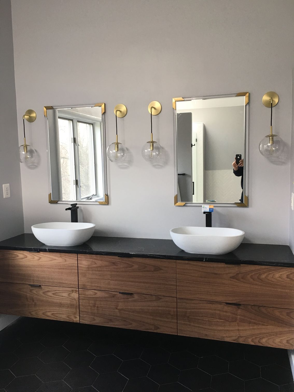 A bathroom with two sinks and two mirrors on the wall.